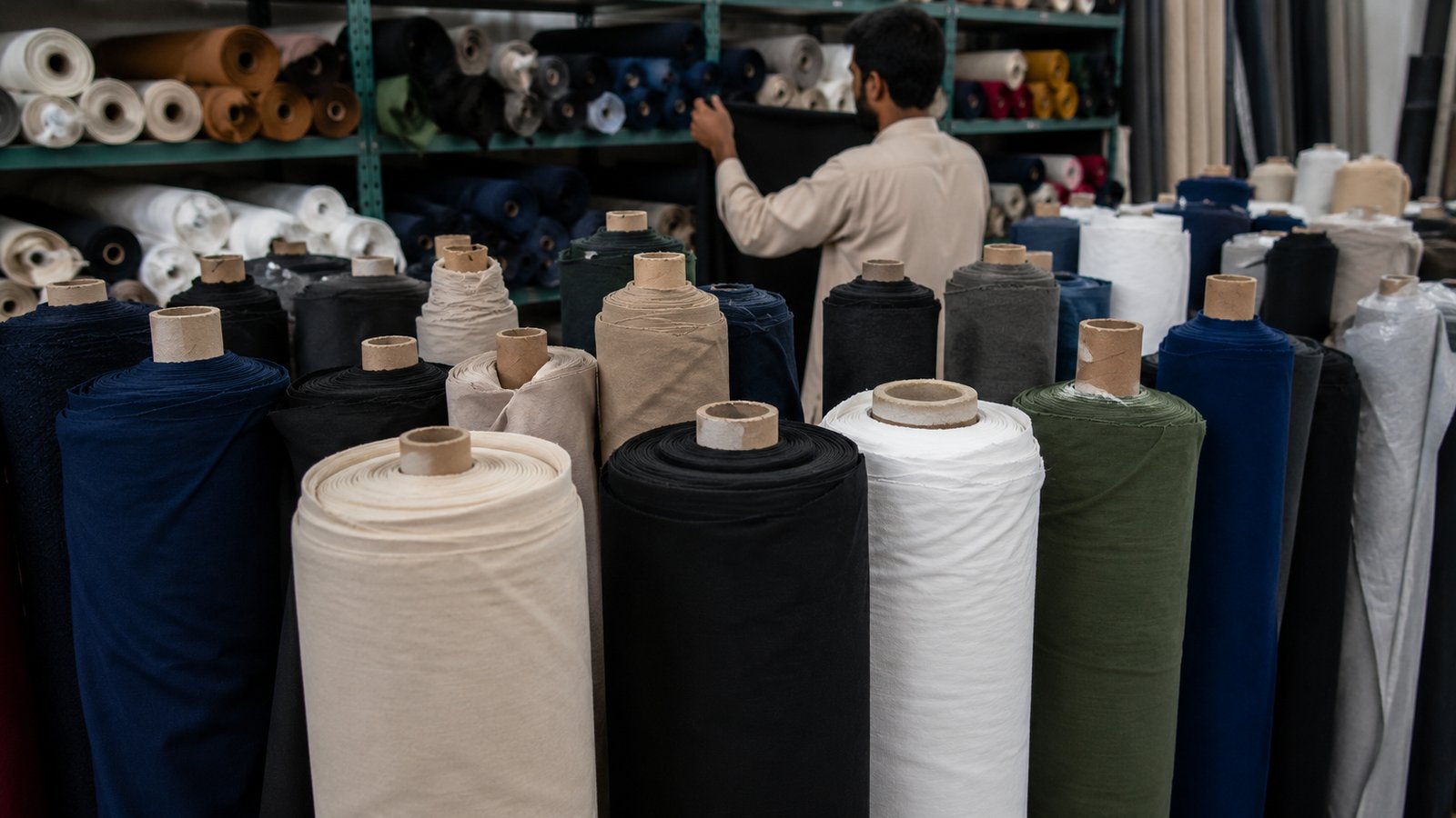 Rolls of fabric in a range of colors on factory shelving